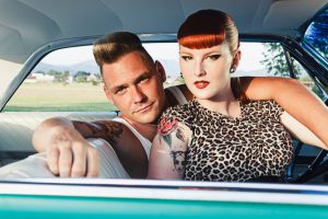 Rockabilly couple sitting in a car. Outdoor photography.