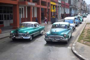 Havana, Cuba, January 18th, 2016: Classic American cars driving on the street. The old-styled American vehicles from 50s are the one of the most popular cars in Cuba.